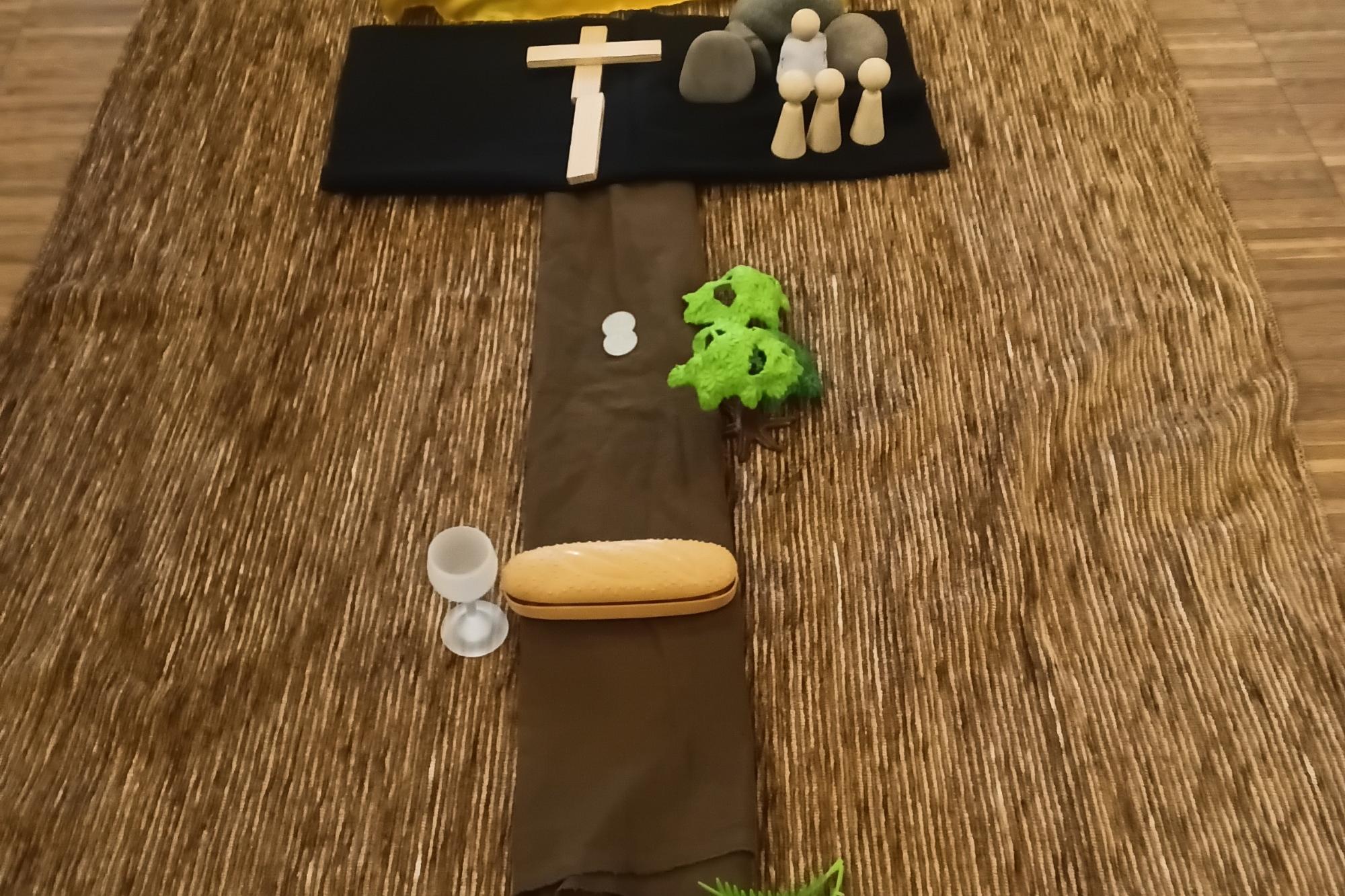 Kreuzweg gelegt von Kindern aus Tüchern, Figuren und weiteren Utensilien inklusive Symbole der Auferstehung Jesu