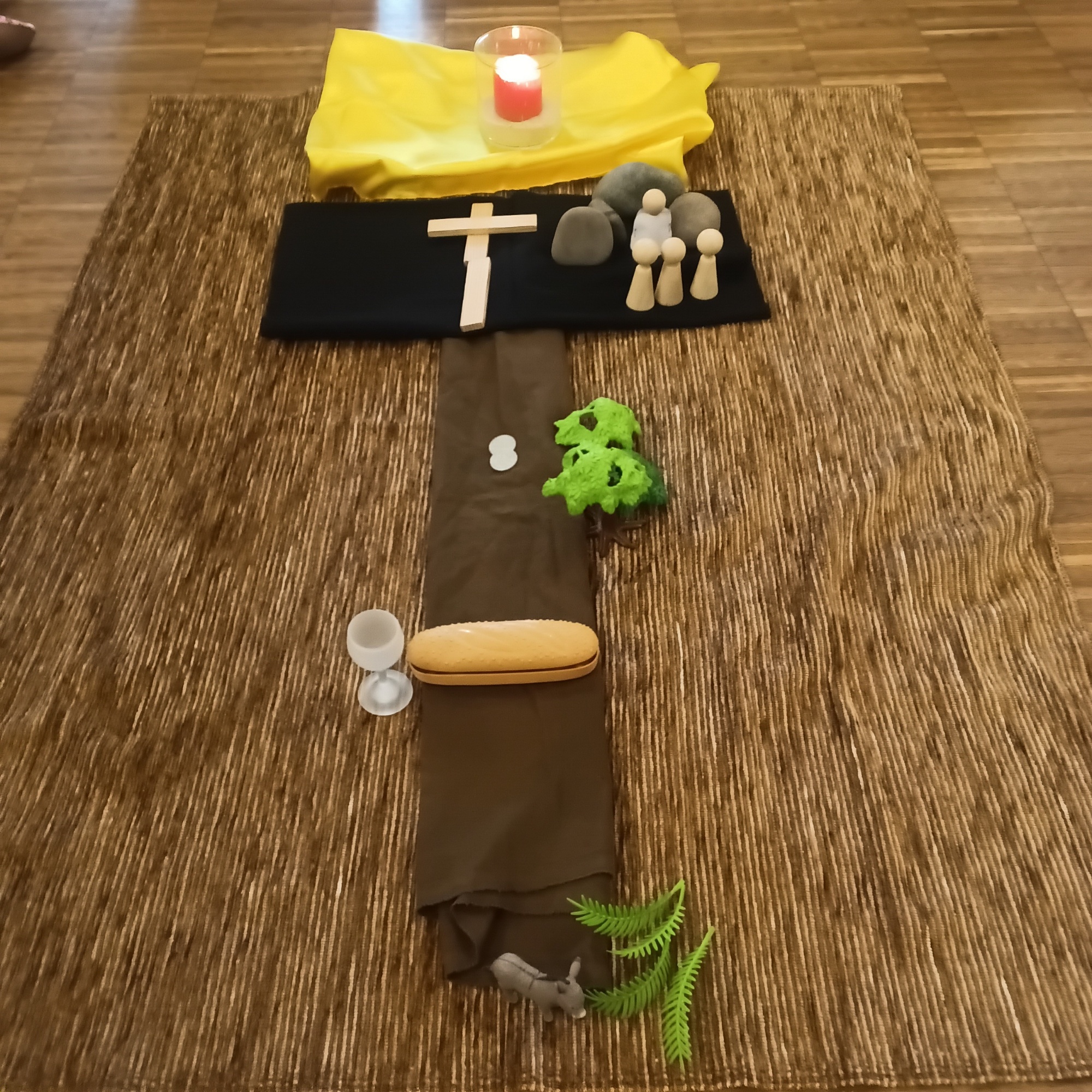 Kreuzweg gelegt von Kindern aus Tüchern, Figuren und weiteren Utensilien inklusive Symbole der Auferstehung Jesu