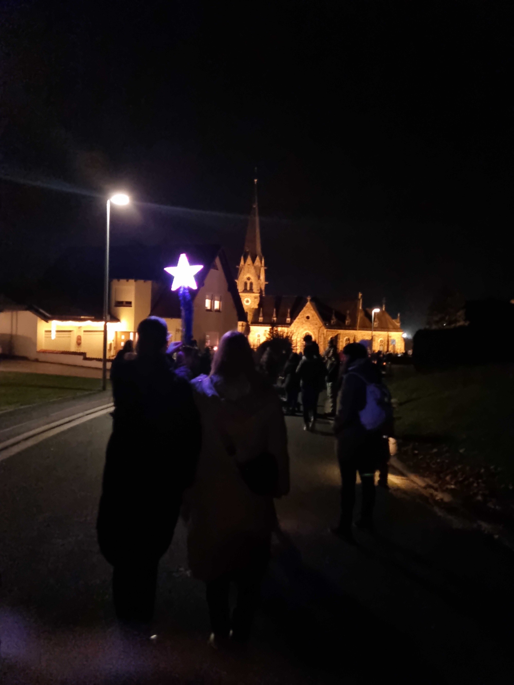 Martinszug mit beleuchteter Kirche im Hintergrund