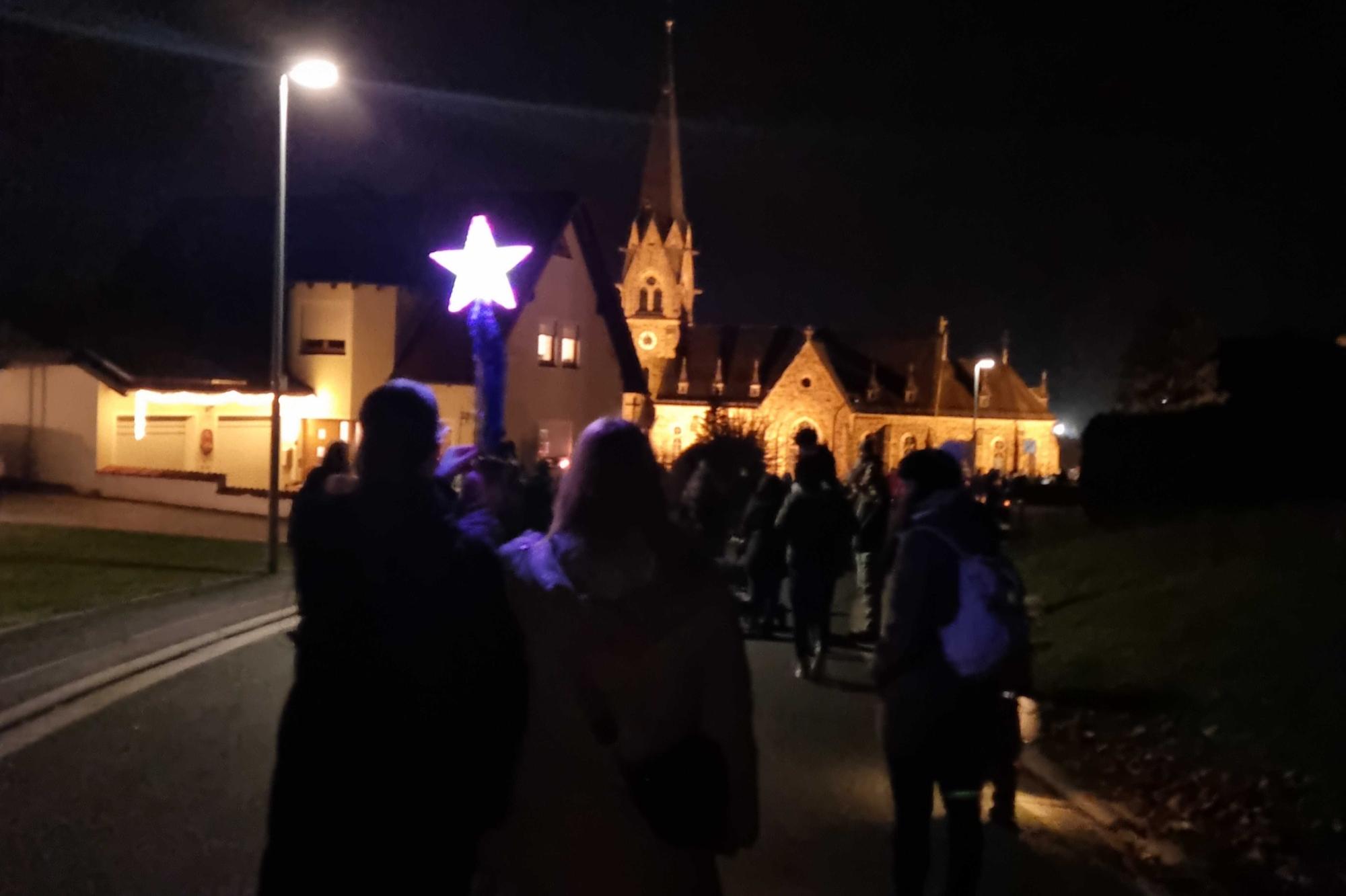 Martinszug mit beleuchteter Kirche im Hintergrund