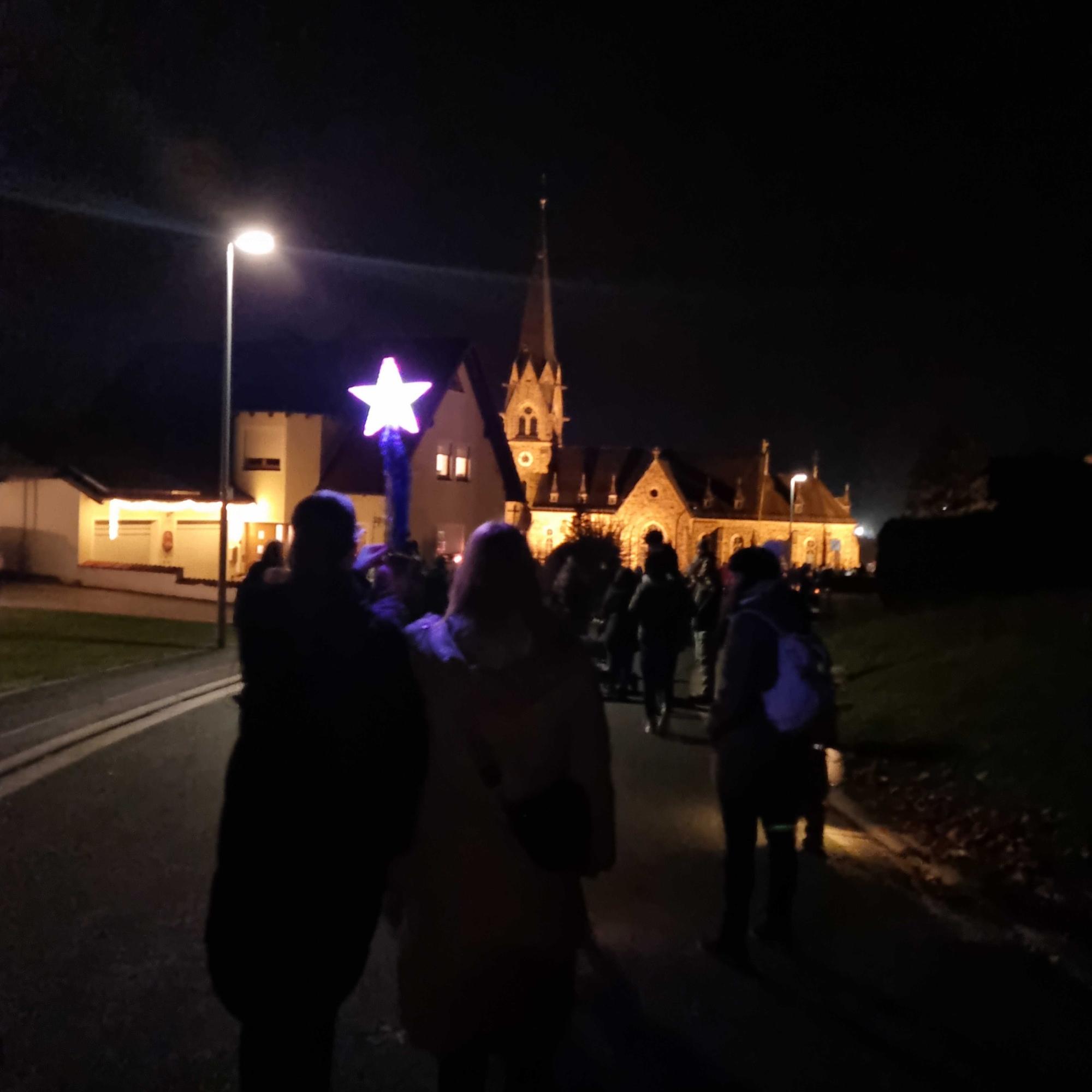 Martinszug mit beleuchteter Kirche im Hintergrund